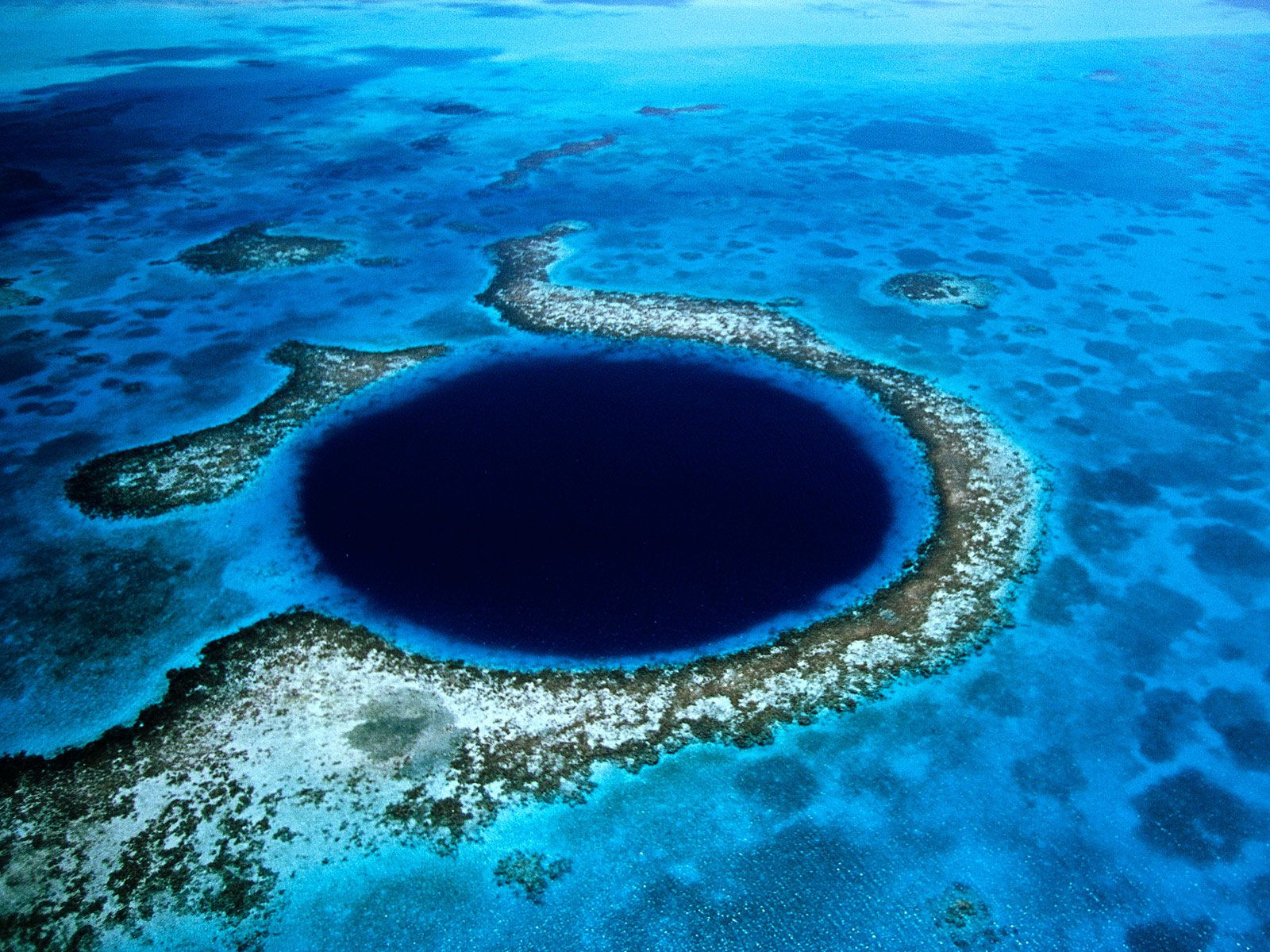 This is the Great Blue Hole—a giant sinkhole located 40 miles off the coast of Belize in the Lighthouse Reef. It formed more than 150,000 years ago and is now a UNESCO World Heritage site. A popular diving destination, the Blue Hole also attracts scientists hoping to find answers buried in its mud. Belize's "blue hole." Photo by Eric Pheterson/flickr/CC BY 2.0
