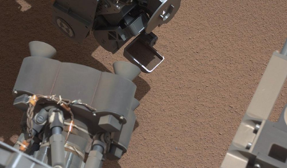 This image from the right Mast Camera (Mastcam) of NASA's Mars rover Curiosity shows a scoop full of sand and dust lifted by the rover's first use of the scoop on its robotic arm. In the foreground, near the bottom of the image, a bright object is visible on the ground. The object might be a piece of rover hardware. Image courtesy of NASA/JPL-Caltech/LANL