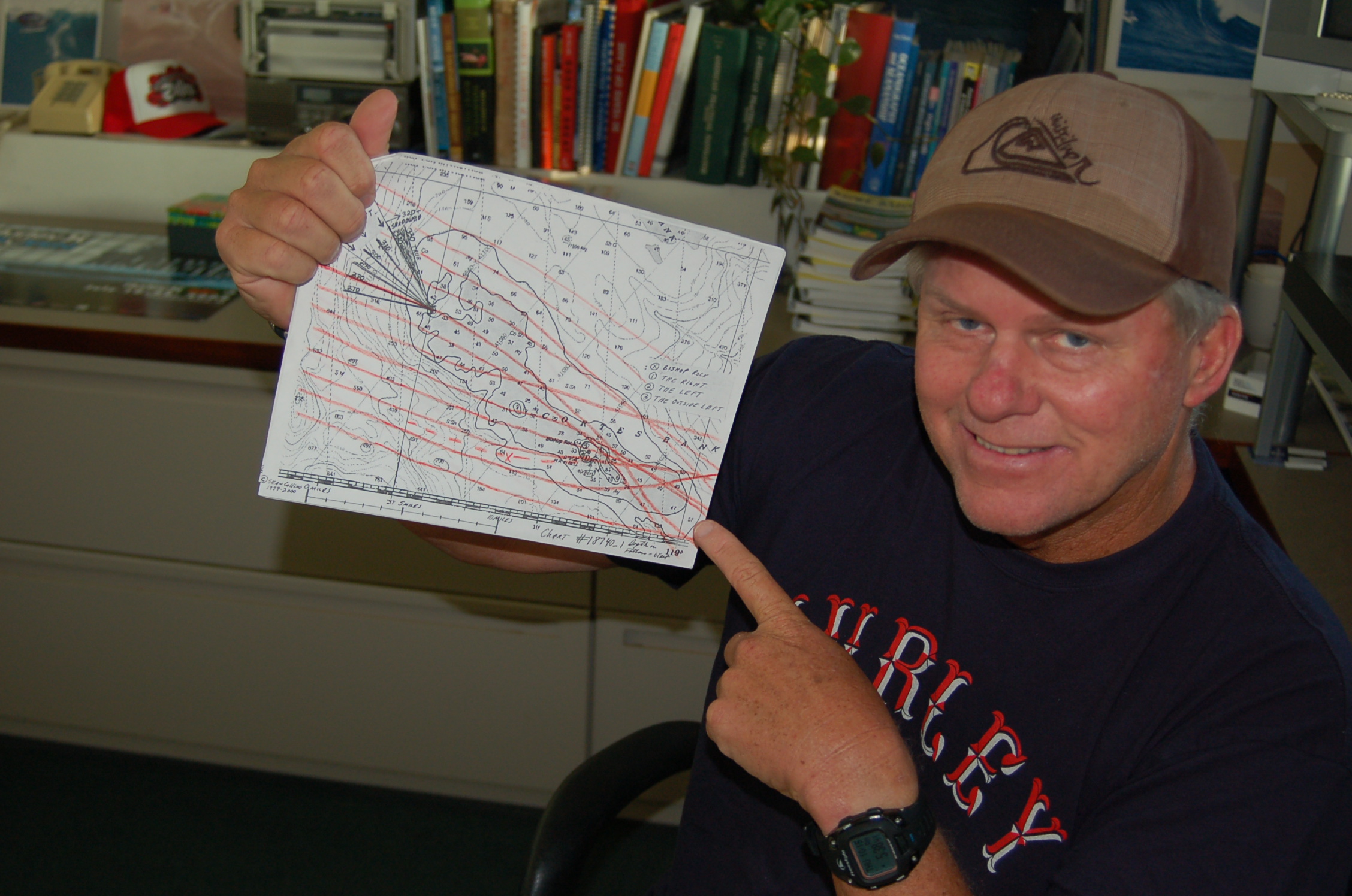 Sean Collins with a hand-drawn map he created years ago to calculate the swell, reef, and bathymetry of the Cortes Bank, a seamount 100 miles off the coast of California where huge waves are surfed. Photo by Chris Dixon