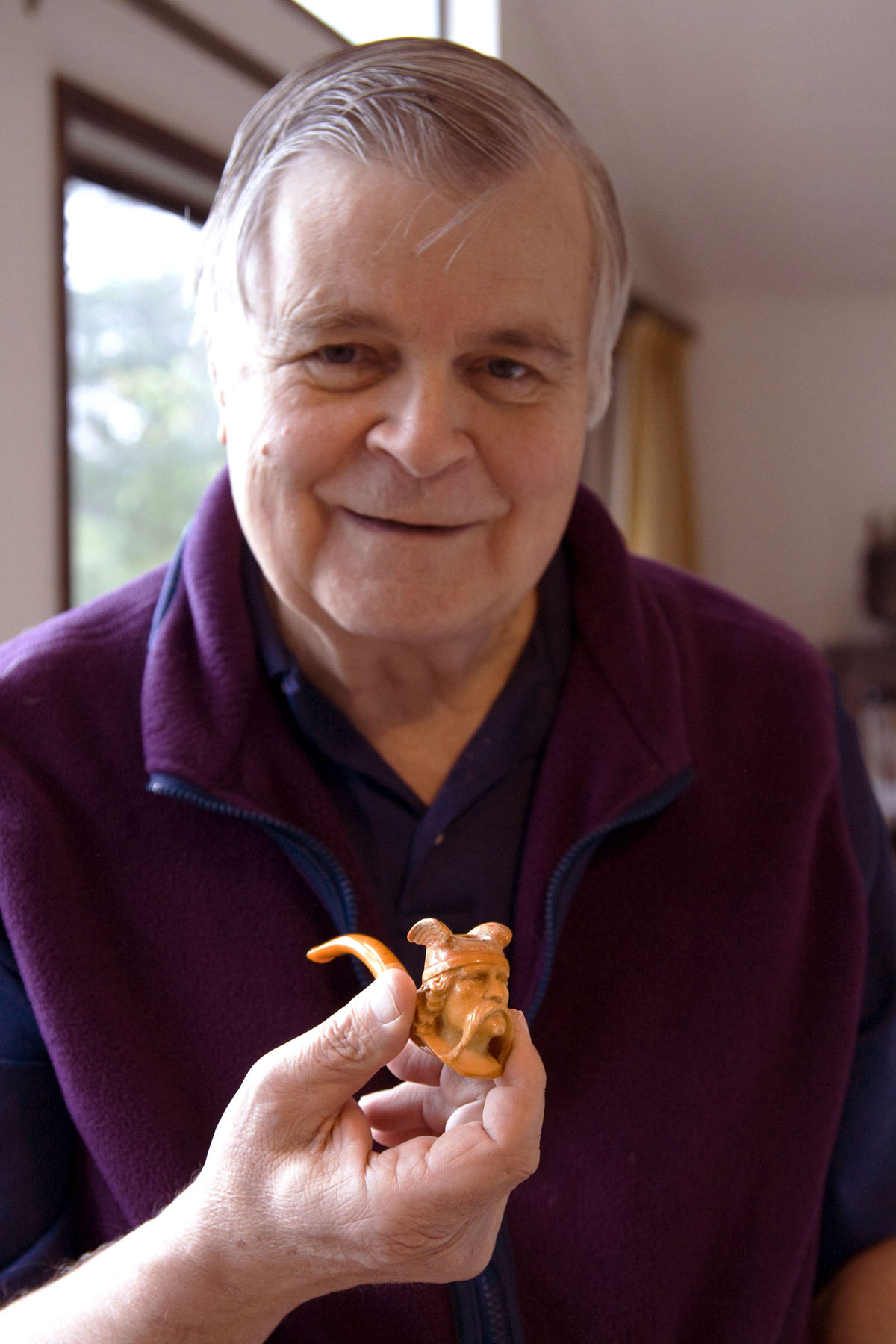 George Poinar holding a Meerschaum pipe with an amber stem. Photo by Roberta Poinar