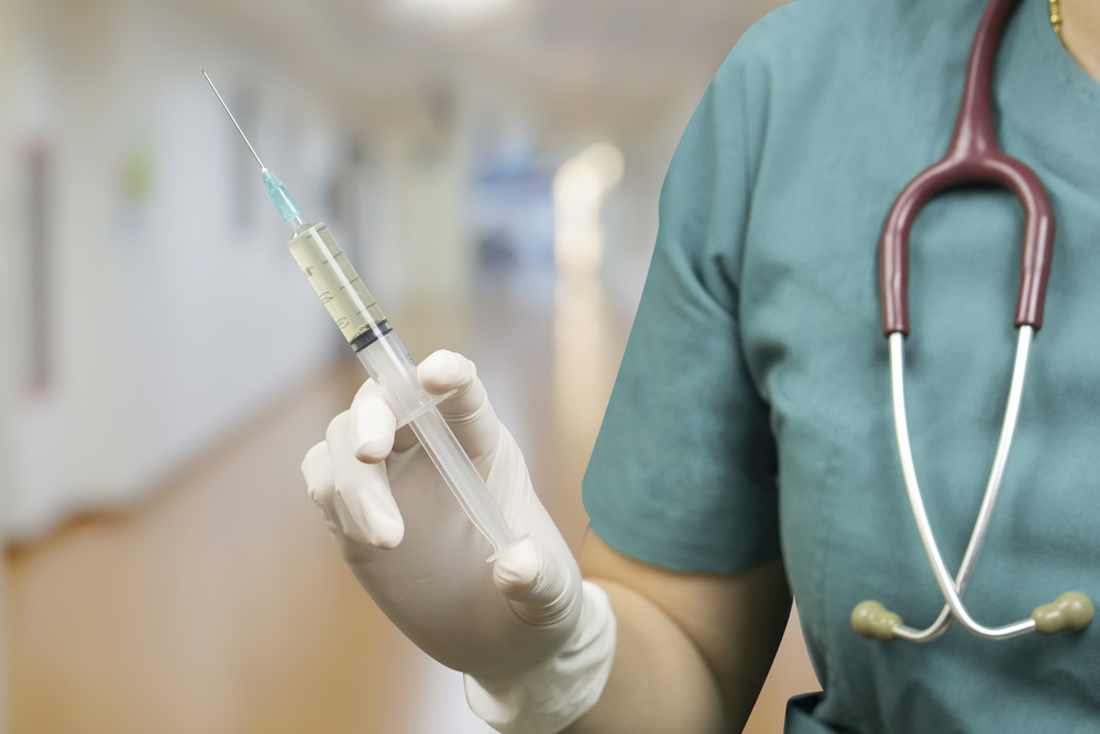 A nurse holding a syringe, from Shutterstock