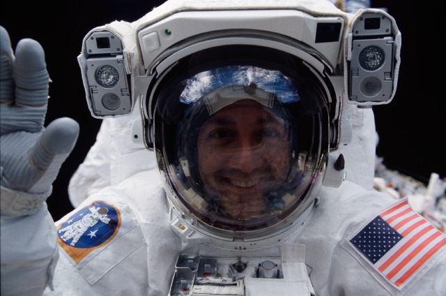 Astronaut Mike Massimino peers into Columbia's crew cabin during a brief break in work on the Hubble Space Telescope. Image Credit: NASA