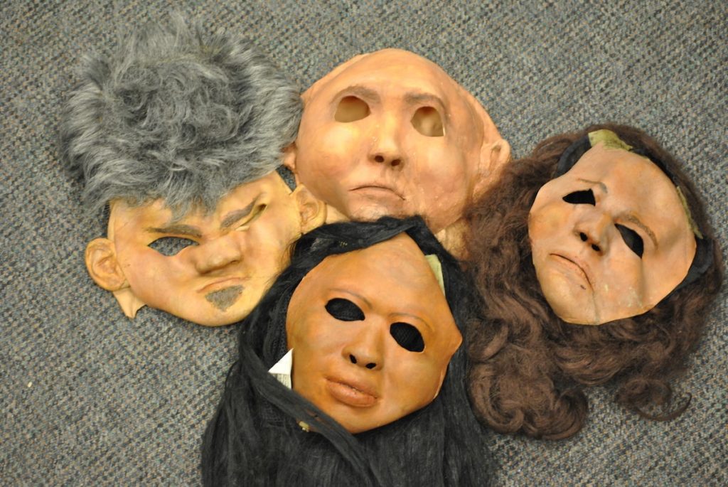 an array of skin-toned research masks with different colored hair