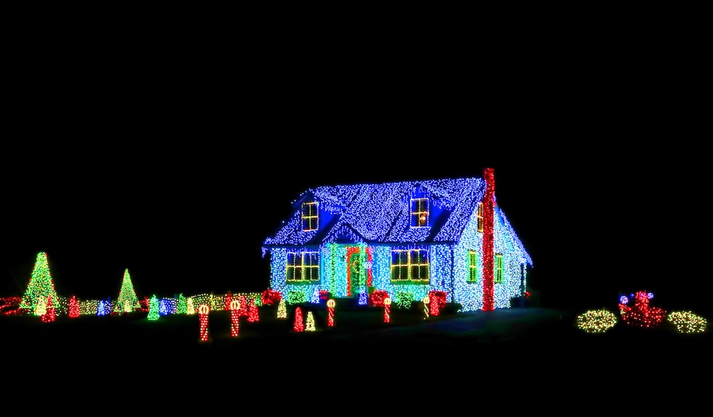 Intense bright colors LED Christmas light show and display on a house and its yard for festive holiday illuminations on a black night