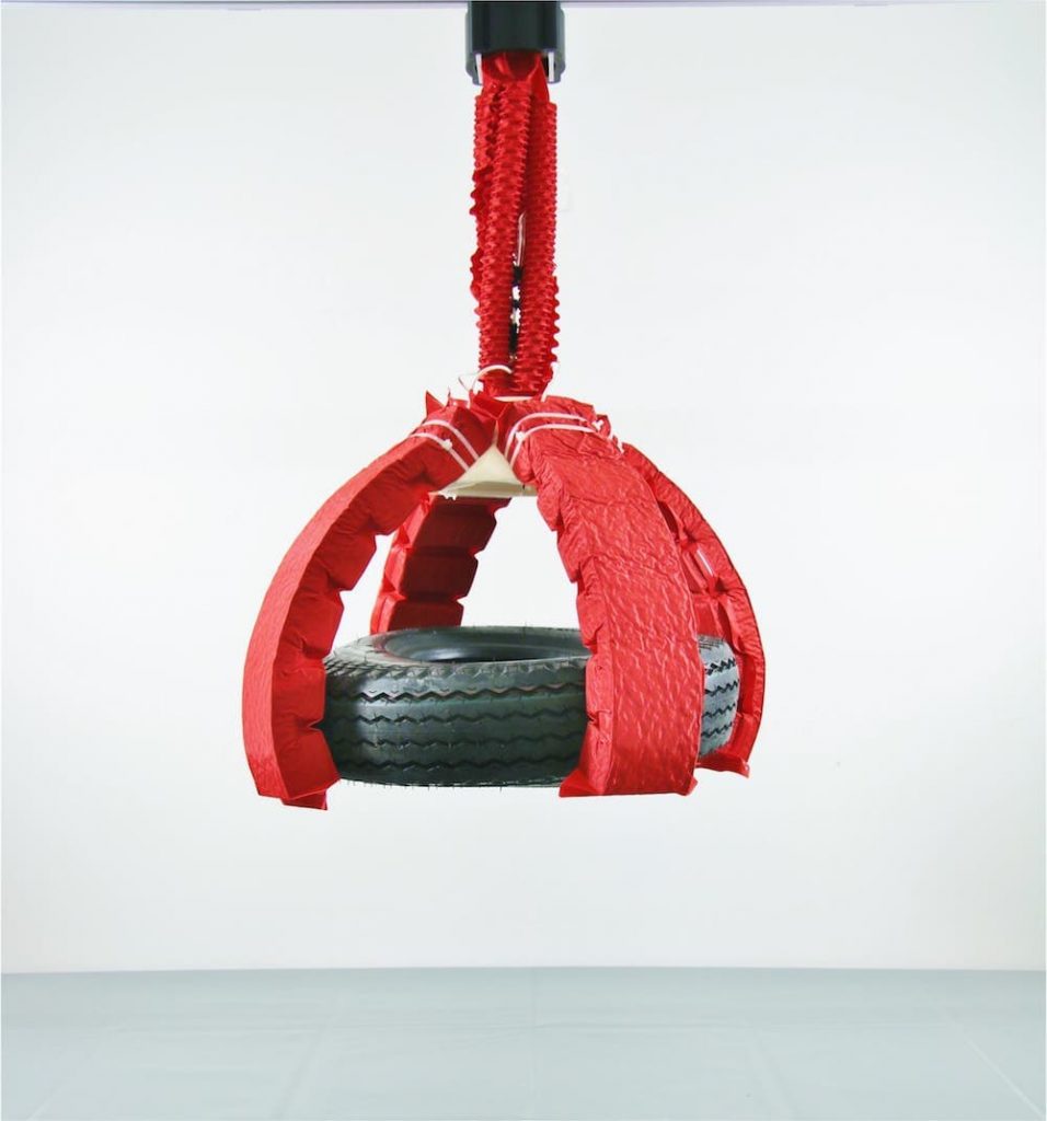 red soft robot arm and claw holding a tire