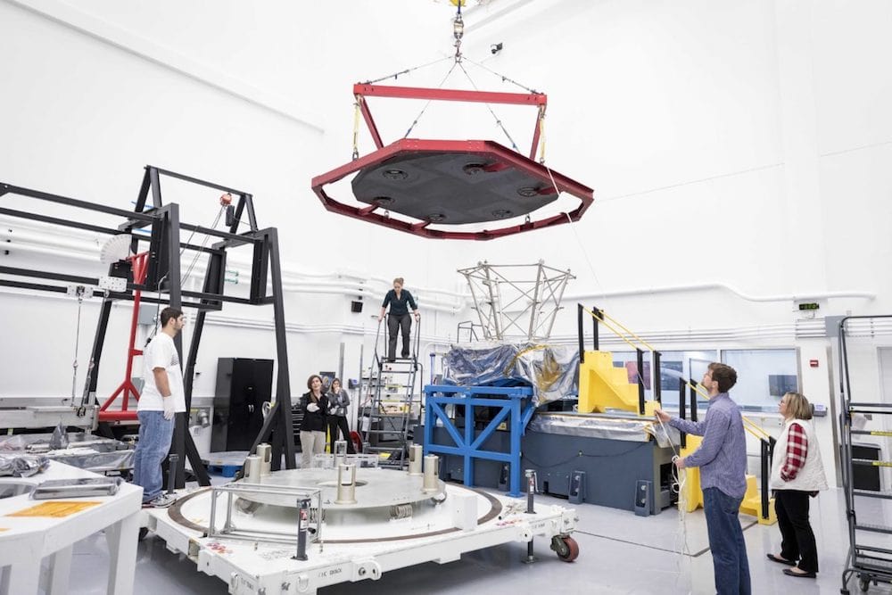 a group of nasa scientists with testing equipment in a white lab