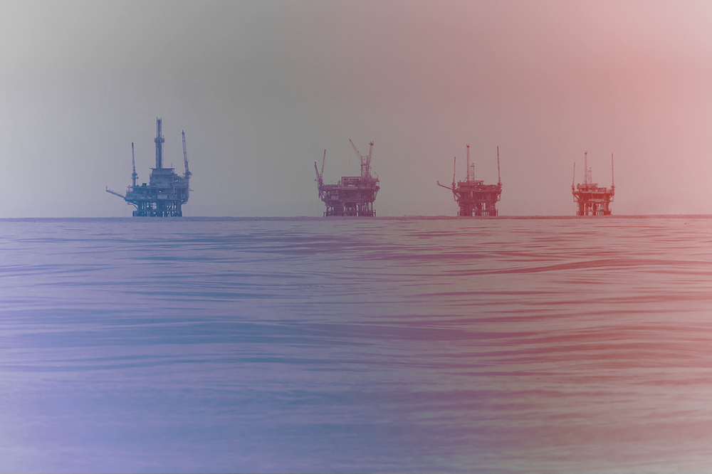 four oil rigs in a row in the ocean