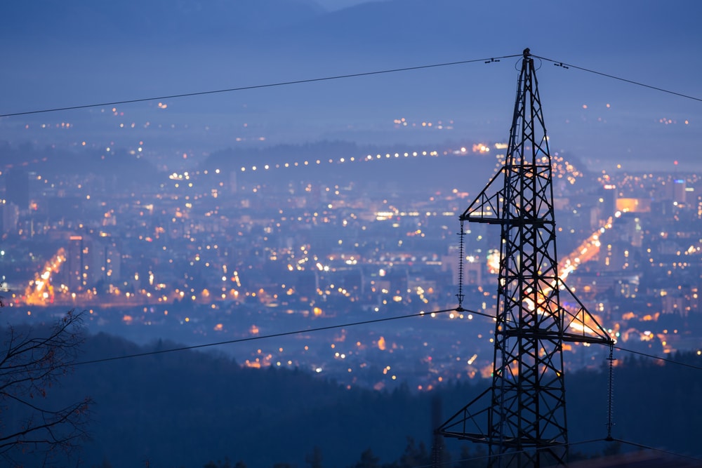 power lines with city lights in the background