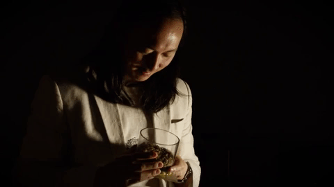 David Hu stroking a bunch of maggots in a container