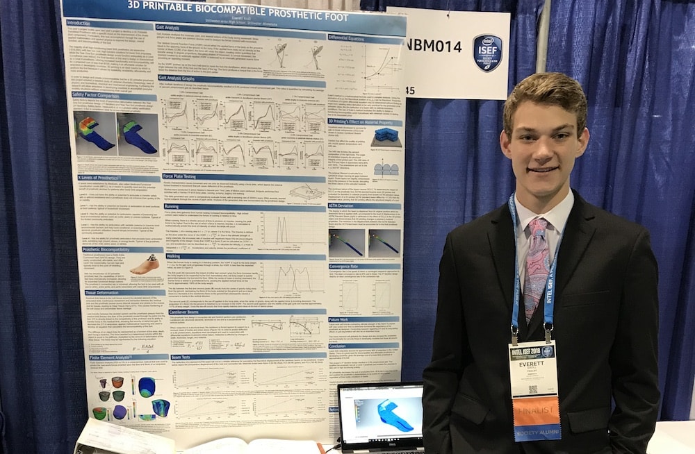 everett kroll stands next to his science project board at the fair