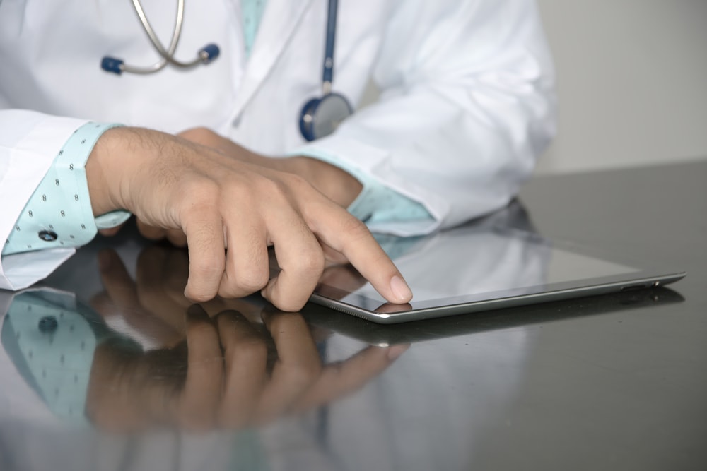 doctor touching tablet on desk