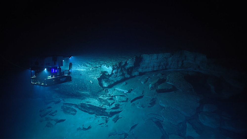 an rov shining a light over a ridge in the ocean