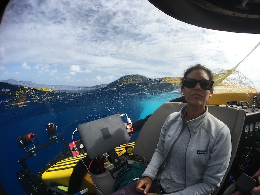 a woman in a submersible getting ready to dive into the ocean