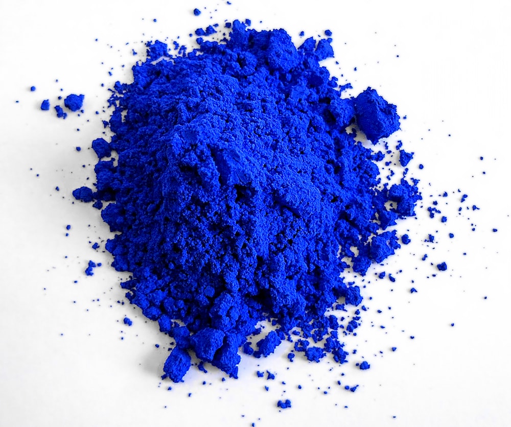 vibrant blue powder on a white background