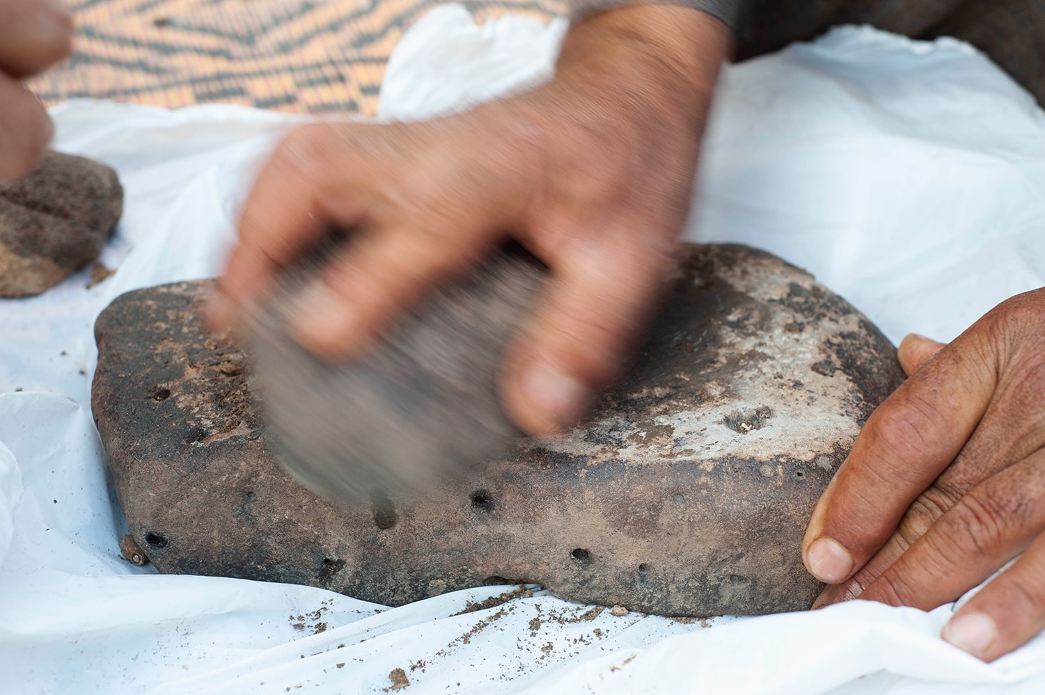 Hand grinding rocks against each other