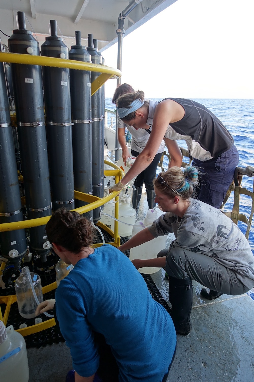 four scientists all huddled around a large machine extracting water