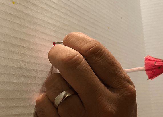 a hand placing a nail on the white board