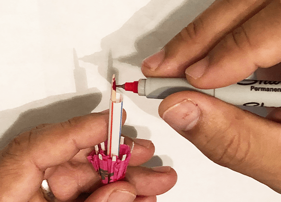 coloring the tip of the toothpick end of the umbrella with a fine tipped sharpie
