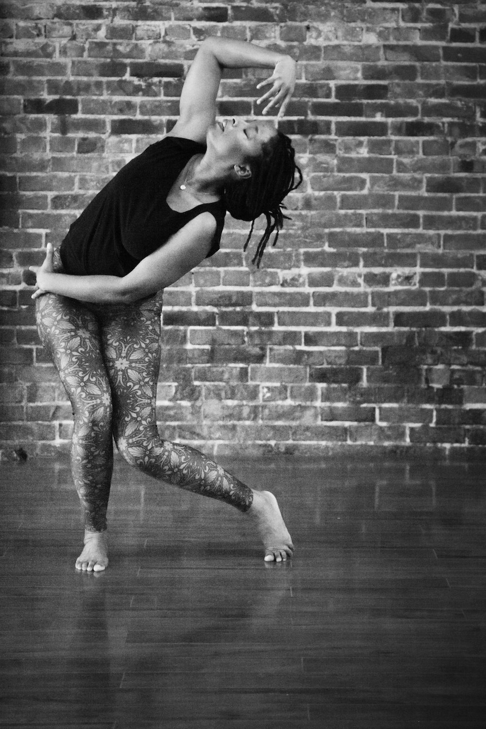 black and white image of dancer standing and moving arm above her head