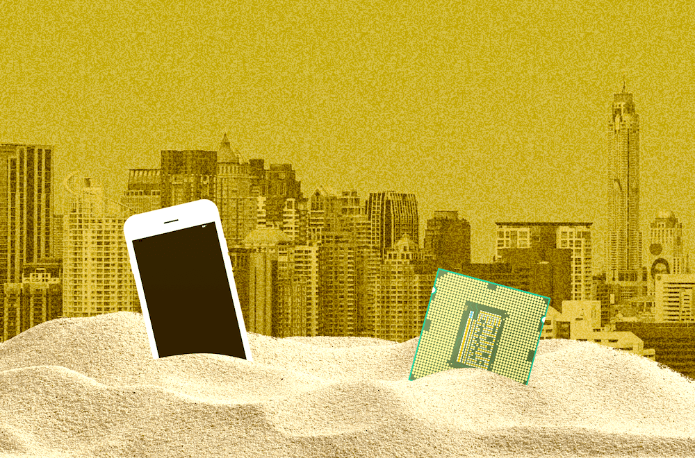 a phone and computer chip buried in sand with city in sandstorm in background