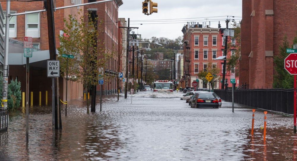 a flooded street with a fire truck driving through tall water