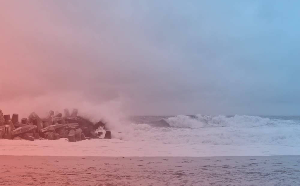 a blue and red tinted photo of a beach with waves crashing to show under a gray sky