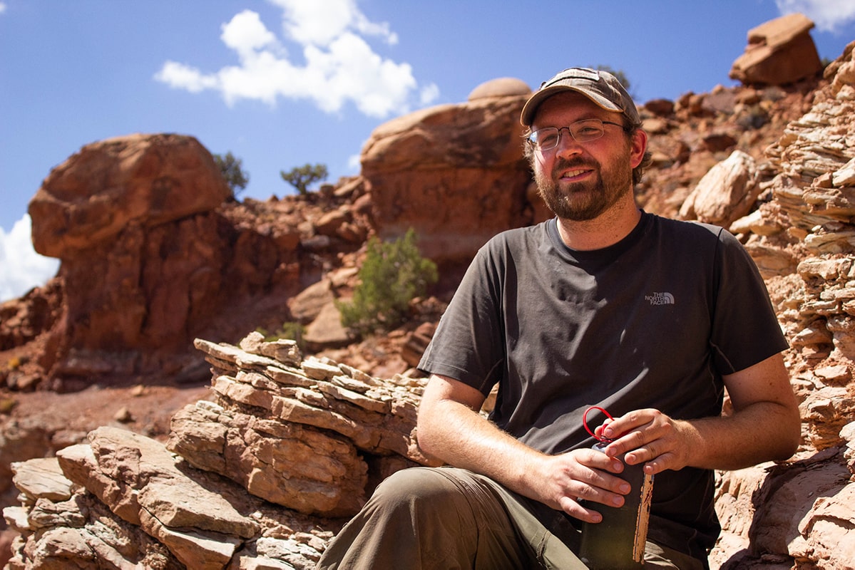 Ranall Irmis, in a baseball cap, in the desert canyons of Utah