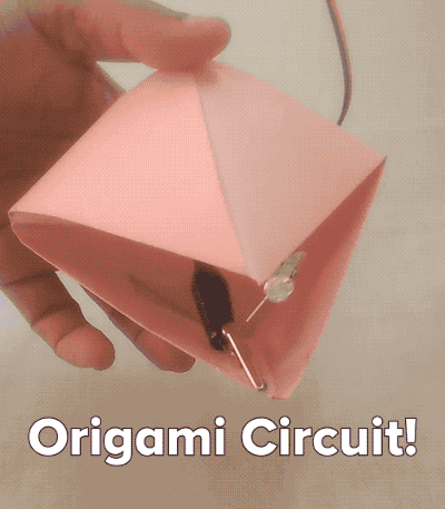 An animated GIF of an origami creation opening and closing to light up a circuit