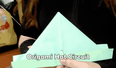 An animated GIF of an origami hat opening and closing to turn on a light