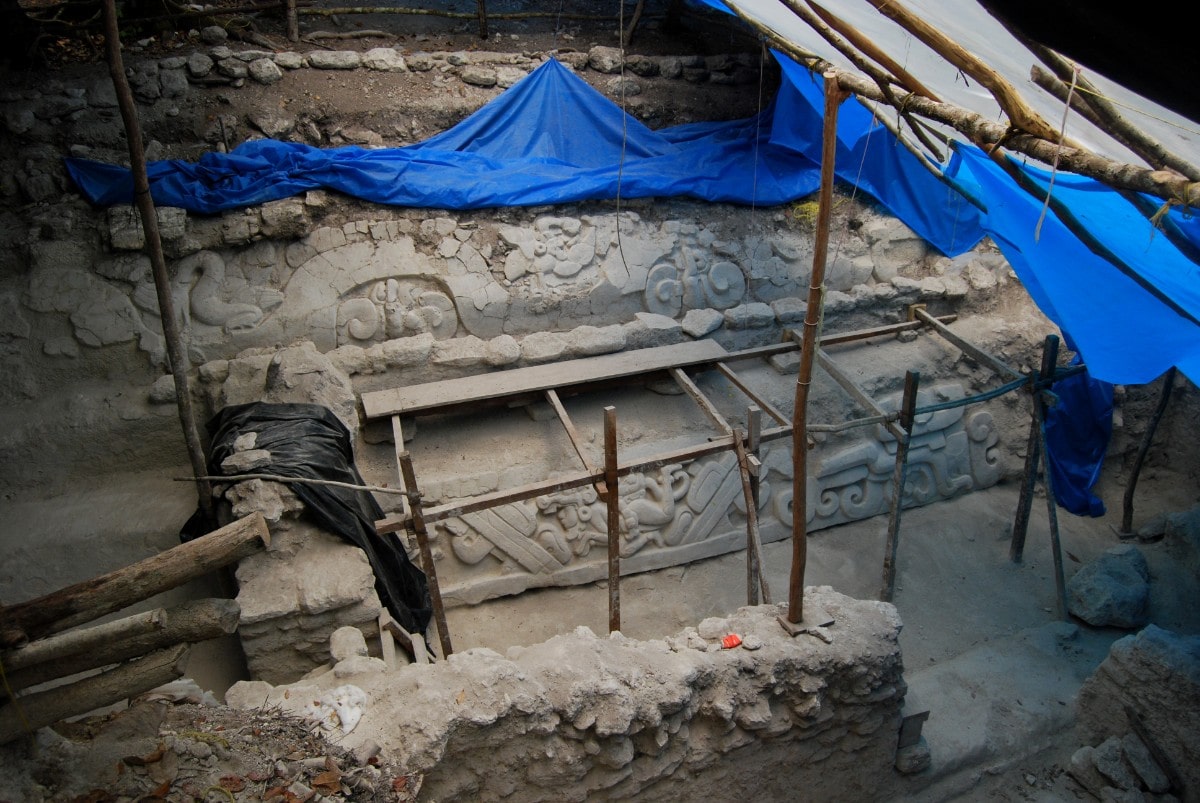 Stucco friezes at El Mirador that adorned the banks of a water-collecting system. the site has blue tarp hanging over it