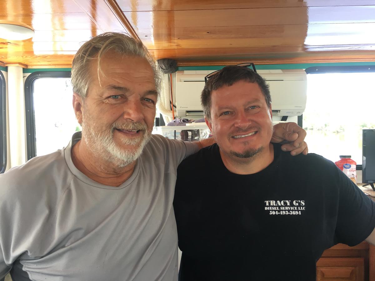 two men stand next to each other smiling