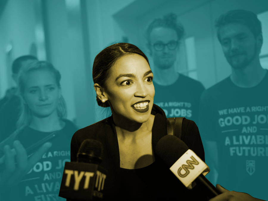 Ocasio-Cortez in the foreground flanked by two tv mics with students behind her