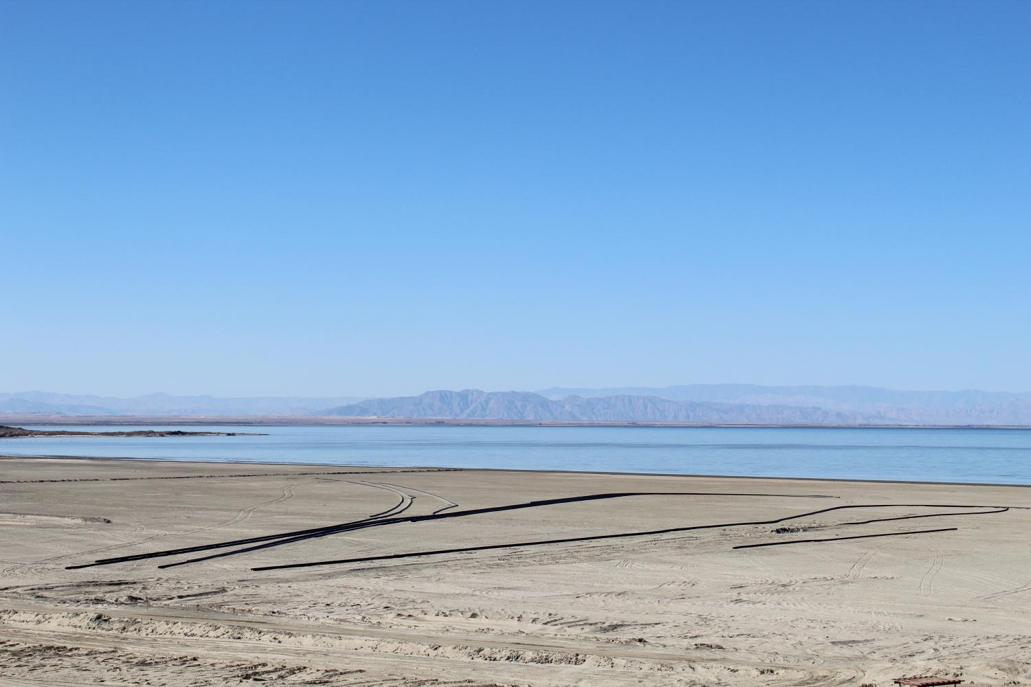 a good stretch of sand and a large body of water with mountains beyond that