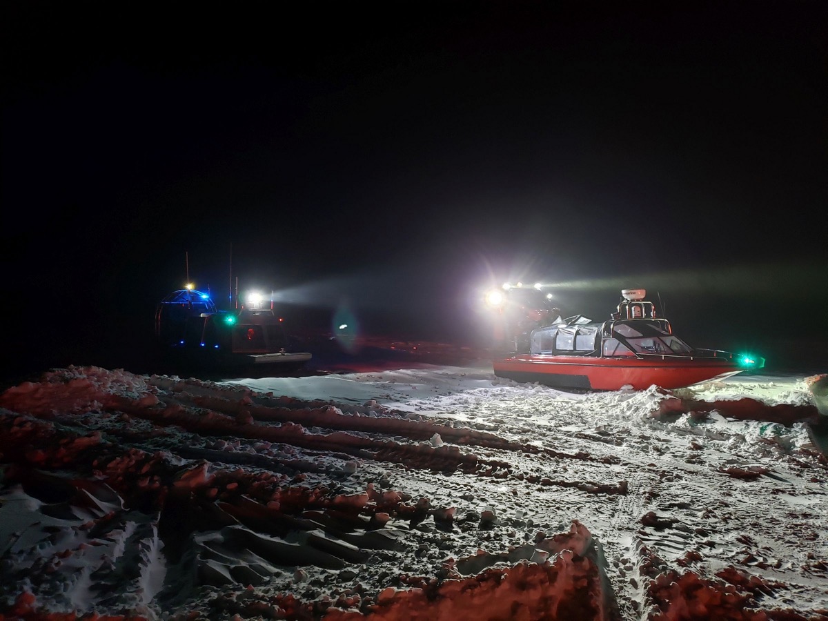 a vessel comes out to a boat that had been stranded on a snow-covered frozen bay