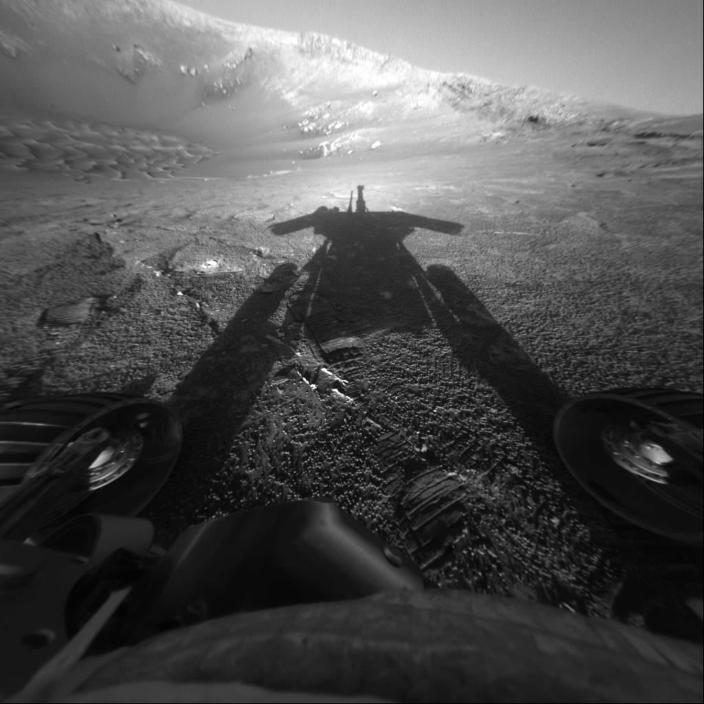 a black and white photo of the shadow of a rover on the dunes of mars