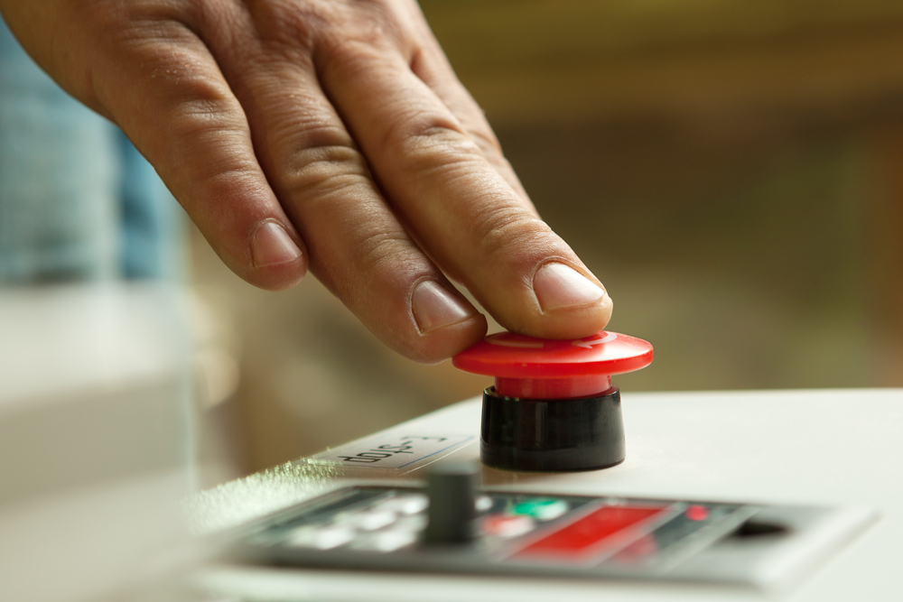 hand pressing down on big red button