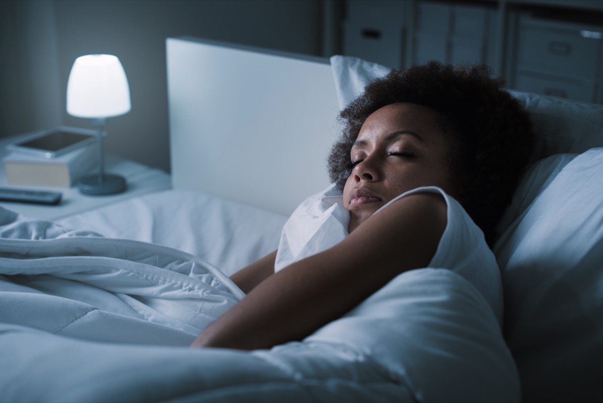 african american woman dozing in bed in the dark