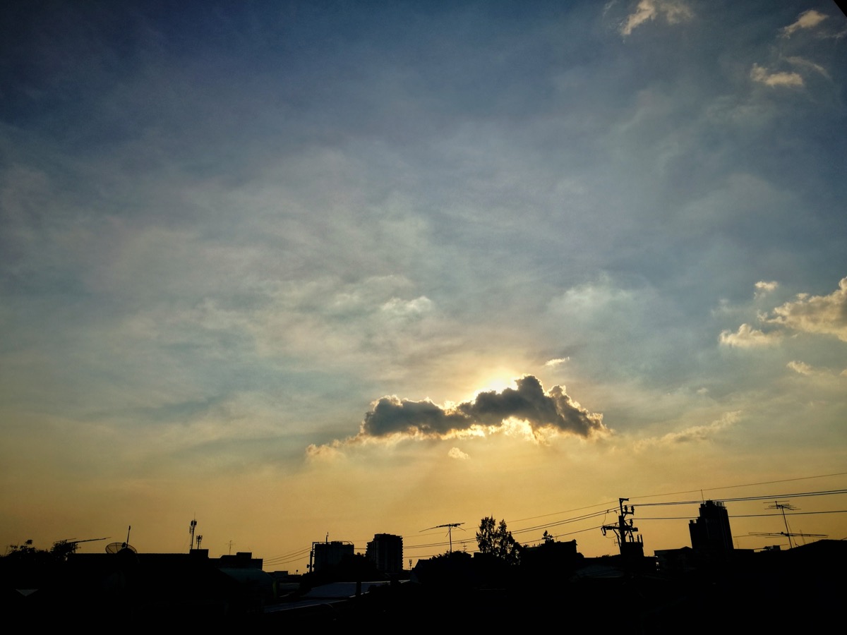 Stratocumulus clouds against a cityscape.