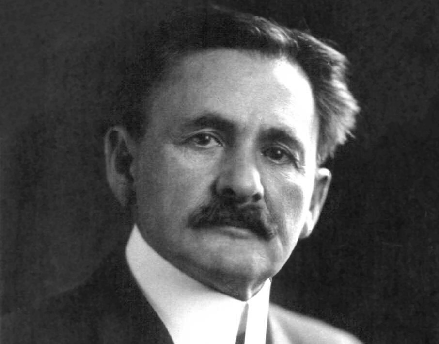 a black and white photo of a white older man with a thick mustache