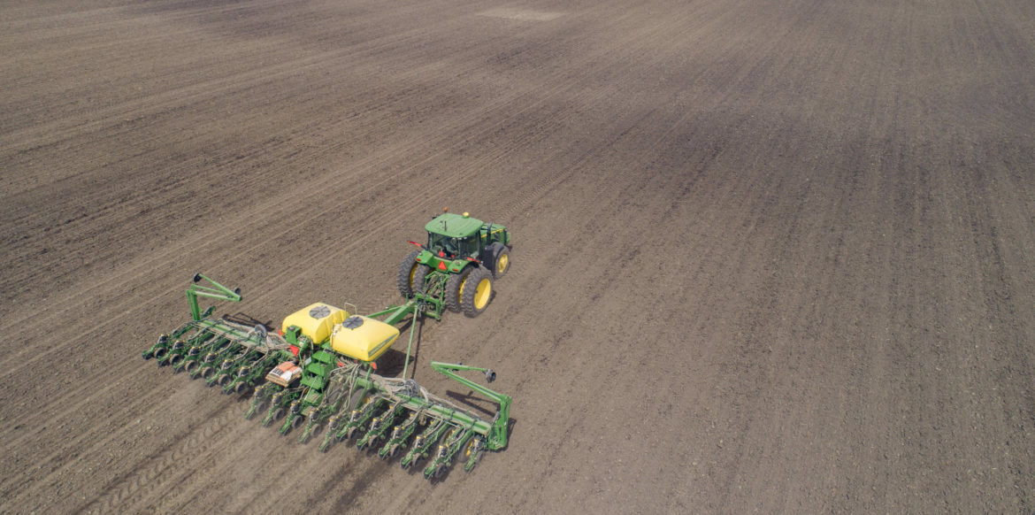 a tractor with a large and wide till travels across a dirt field