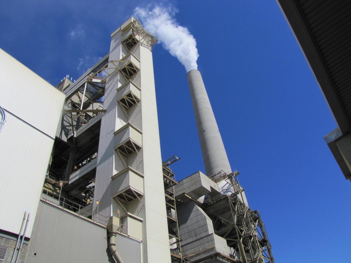 a power plant, with a giant tall smoke stack