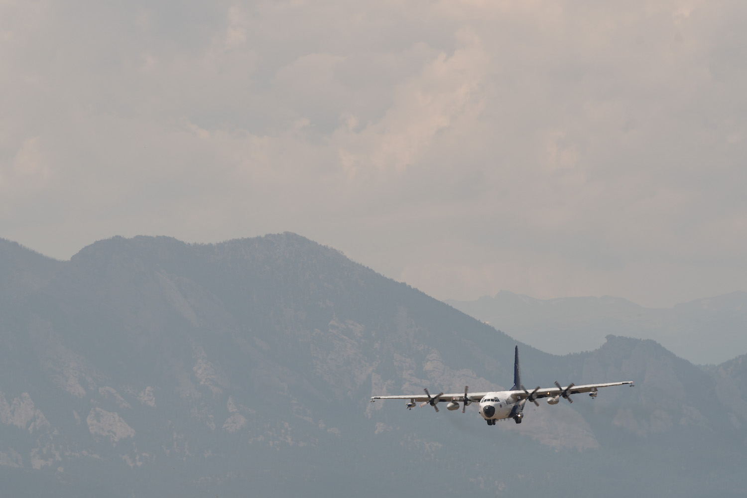 a large propellor plane against the backdrop of smoky mountains