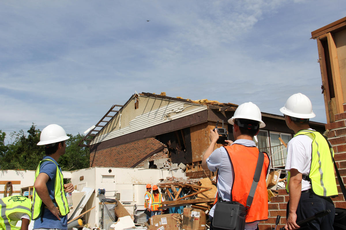 inspectors fly a drone above a tornado-ravaged apartment complex