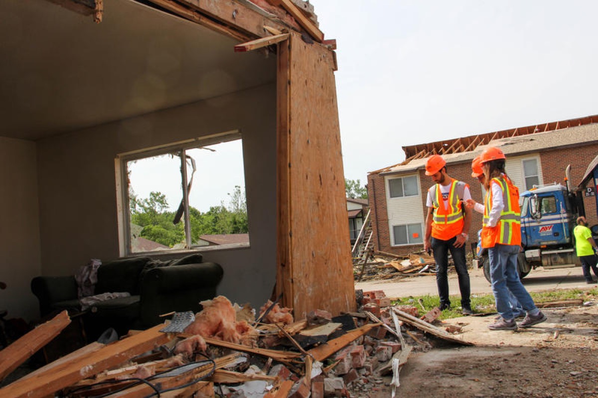 Two inspectors view a damaged home