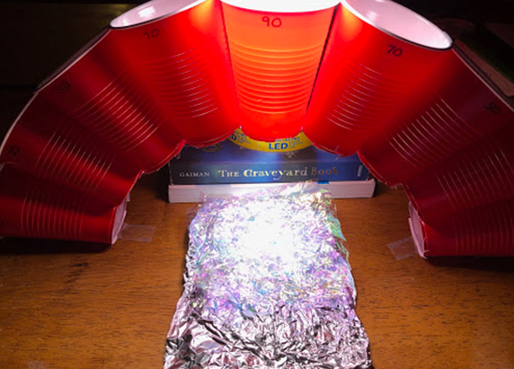 another slightly zoomed out view of the arch of cups, light, and aluminum