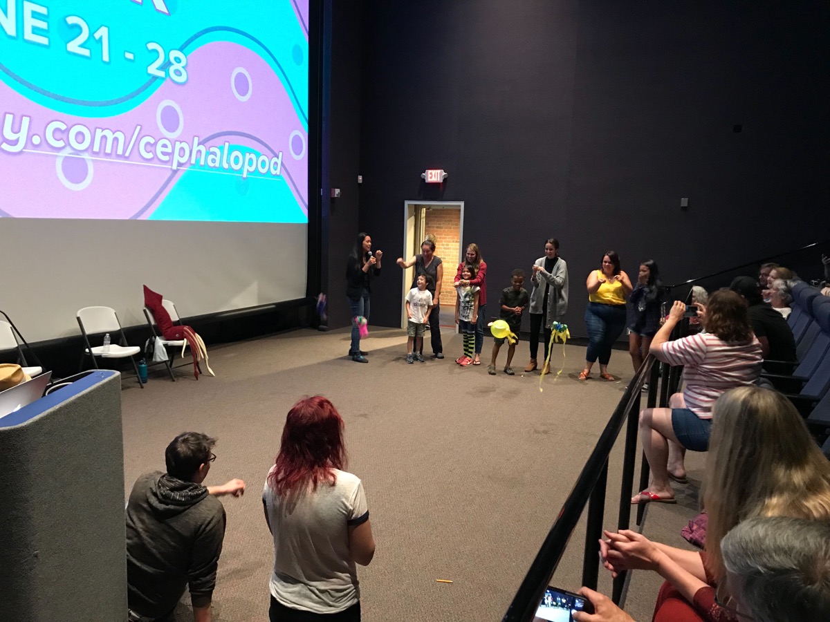 kids line up on stage with different colored balloons designed as squid