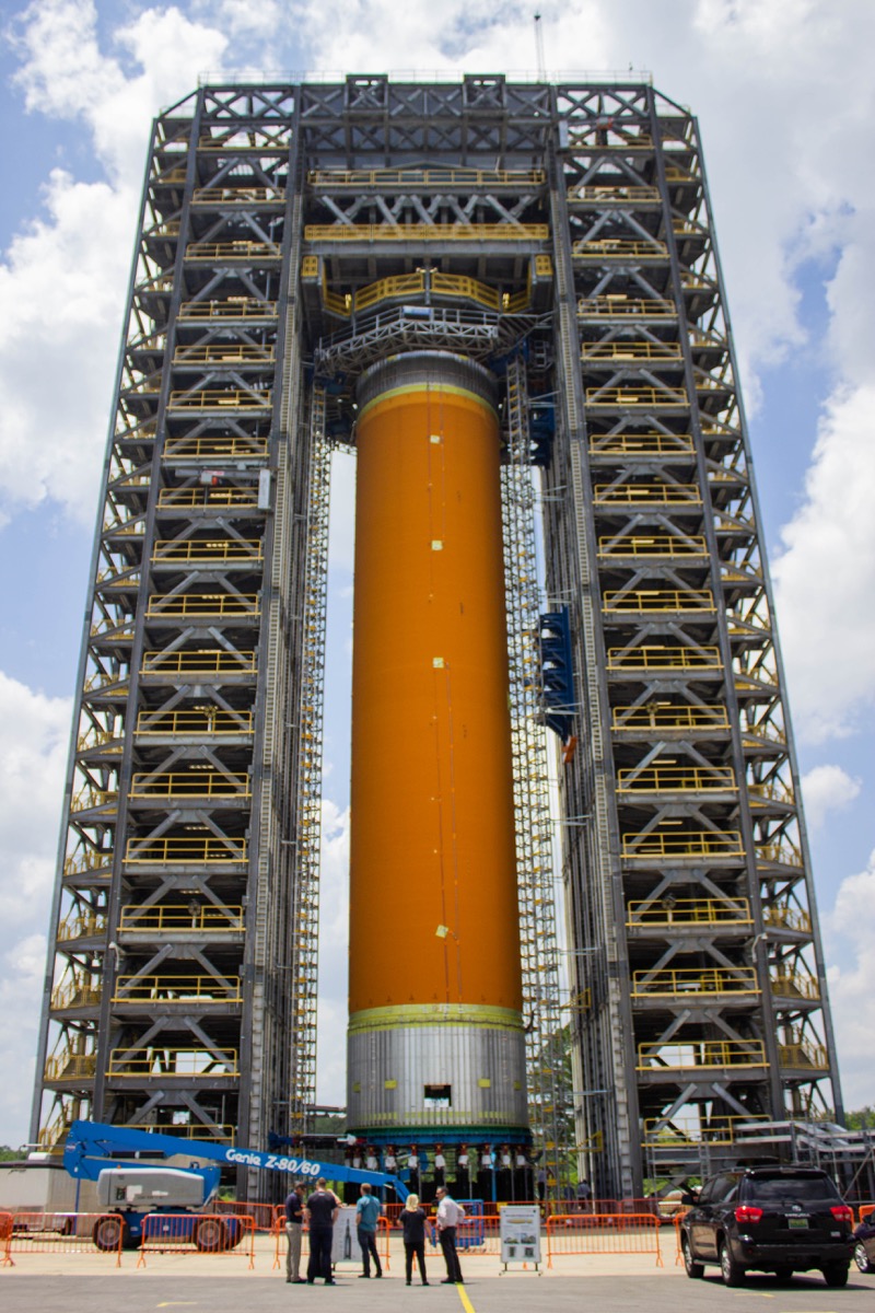 a large orange column tank that is braced by huge scaffolding