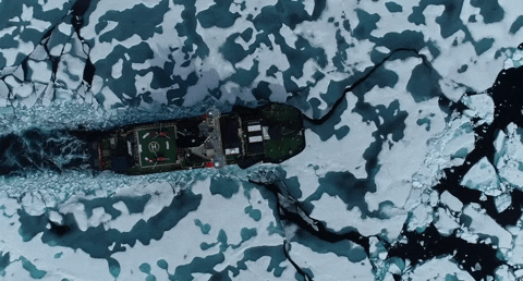an overhead shot of a ship breaking through ice