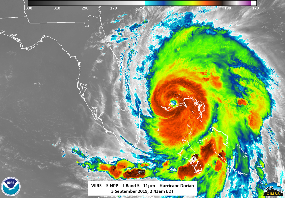 a satellite image of a hurricane over the Bahamas nearing the coast of florida. its center is a dark orange red, indicating its intensity