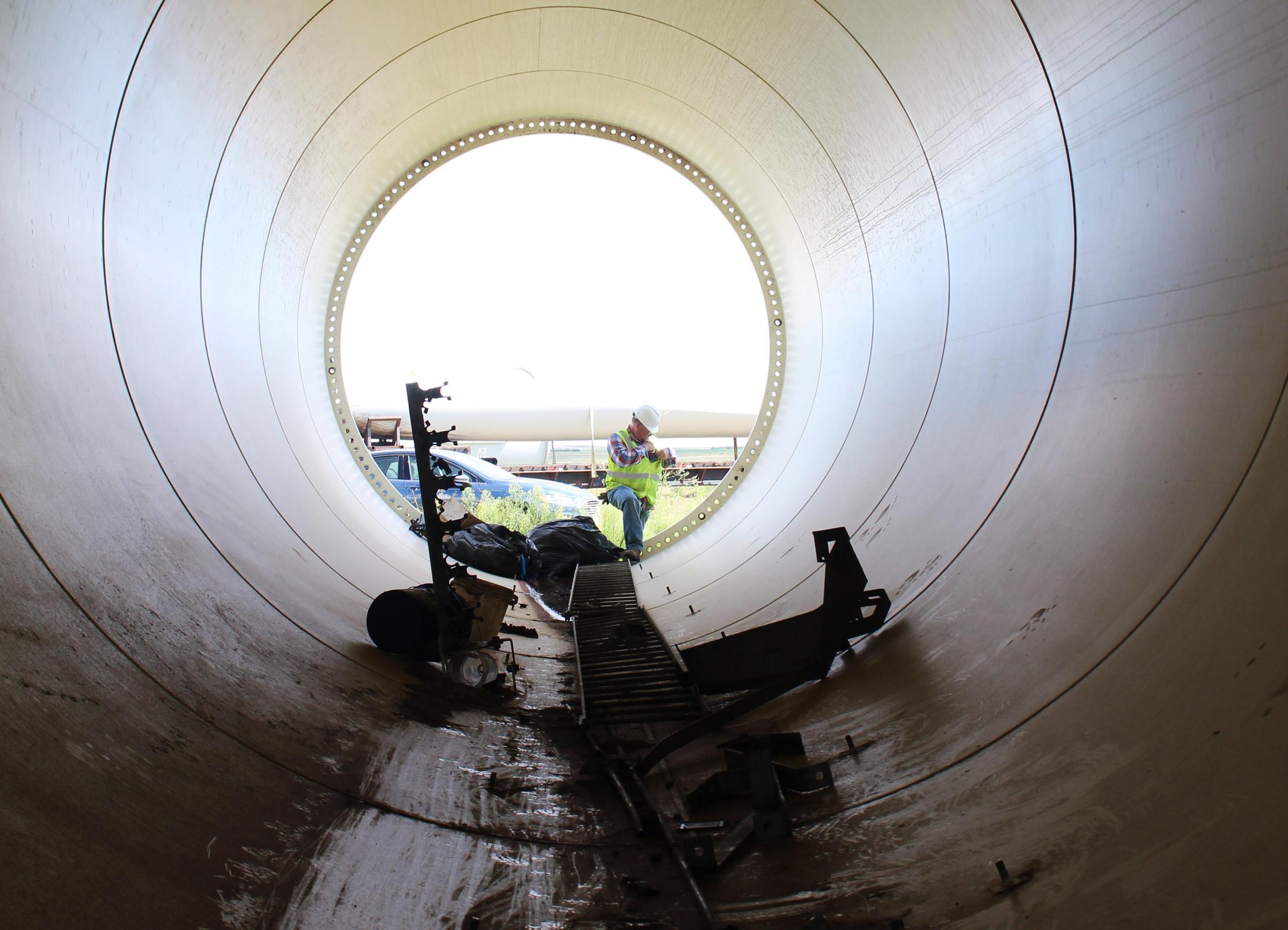a photo taken from inside a long tube of a piece from a wind turbine